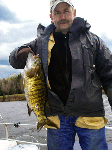 Chris Matlack with a fat small mouth bass taken on Lake Wallace (Wallace Pond) in Vermont's Northeast Kingdom - Click for larger image Photo of fisherman with huge bass taken from Wallace Pond (Lake Wallace) in Vermont's Northeast Kingdom